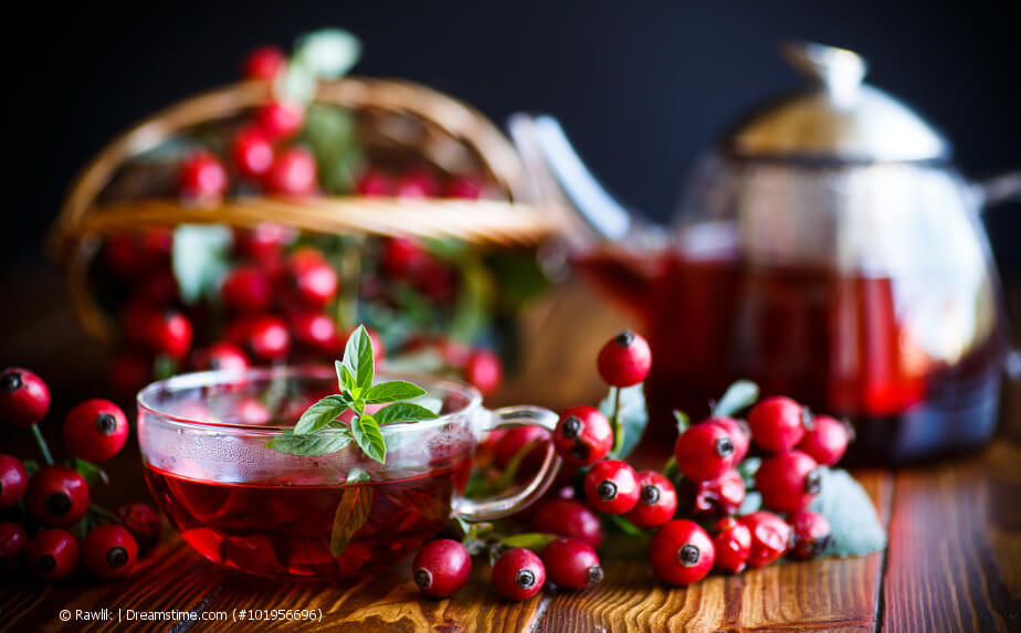 Hagebuttentee im Glas mit frischen Hagebutten